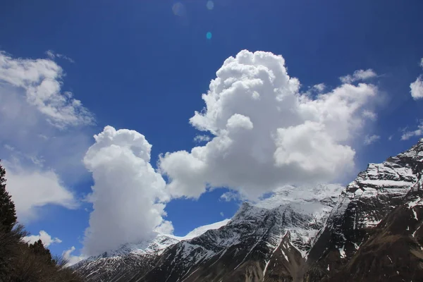 Montanhas nevadas contra o céu azul com nuvens brancas. Montanha — Fotografia de Stock