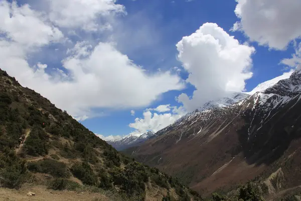 Snowy mountains against the blue sky with white clouds. Mountain