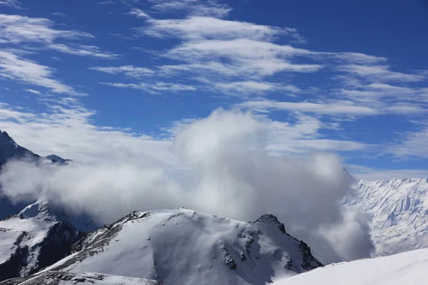 Снежные горы против голубого неба с белыми облаками. Гора — стоковое фото