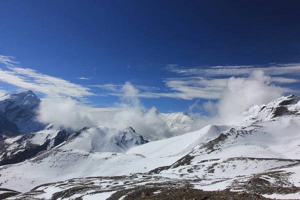 Sněžné hory proti modré obloze s bílými mraky. Mountain — Stock fotografie