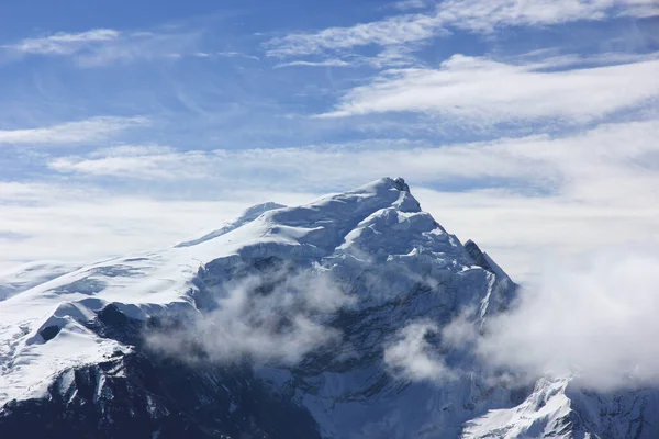 Montanhas nevadas contra o céu azul com nuvens brancas. Montanha — Fotografia de Stock