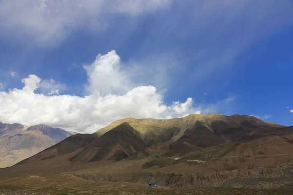 Montañas marrones contra el cielo azul con nubes blancas —  Fotos de Stock