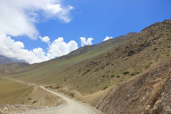 Vuile weg in de bergen van Nepal op een achtergrond van blauwe lucht — Stockfoto