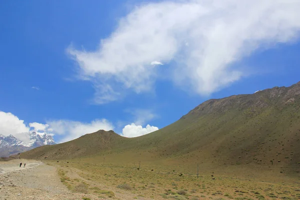 Camino de tierra en las montañas de Nepal sobre un fondo de cielo azul —  Fotos de Stock