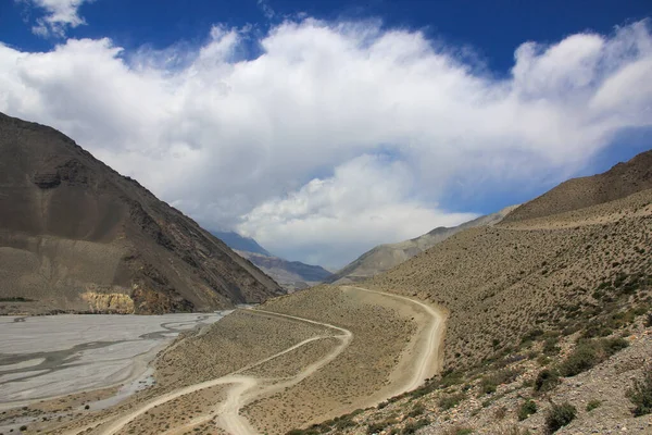 Грязная дорога в горах Непала на фоне голубого неба — стоковое фото
