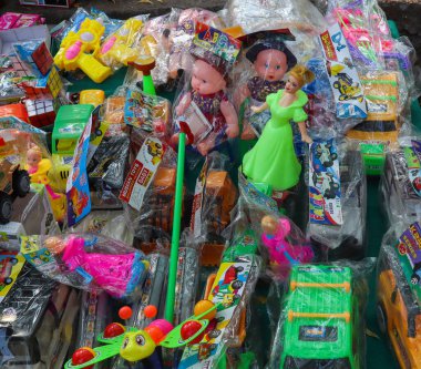 Yol kenarındaki bir oyuncakçıda satılık çocuk oyuncakları ve bebekler.