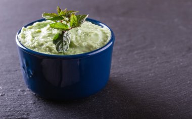 Blue bowl with wasabi dip with piece of herb clipart