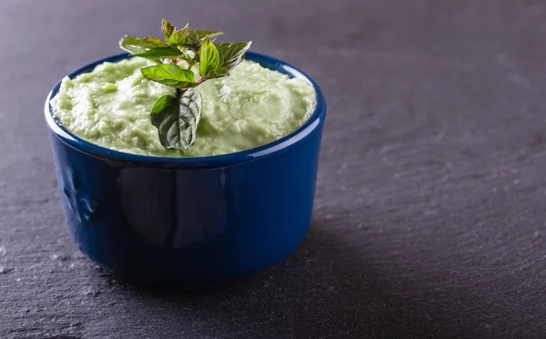 Blue bowl with wasabi dip with piece of herb — Stock Photo, Image