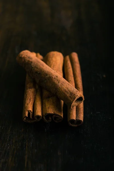 Čtyři kusy skořice koření na tmavé dřevo — Stock fotografie