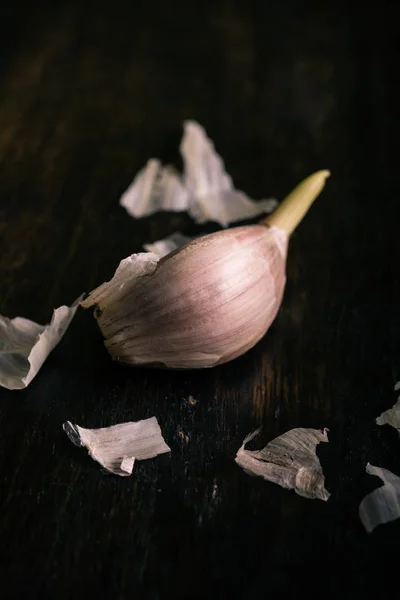 Spicchio d'aglio singolo sul tavolo di legno scuro — Foto Stock