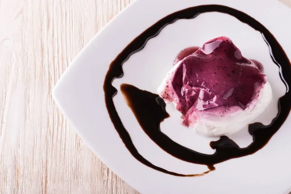 Vista superior de postre cremoso con salsa de arándanos y cobertura de chocolate —  Fotos de Stock