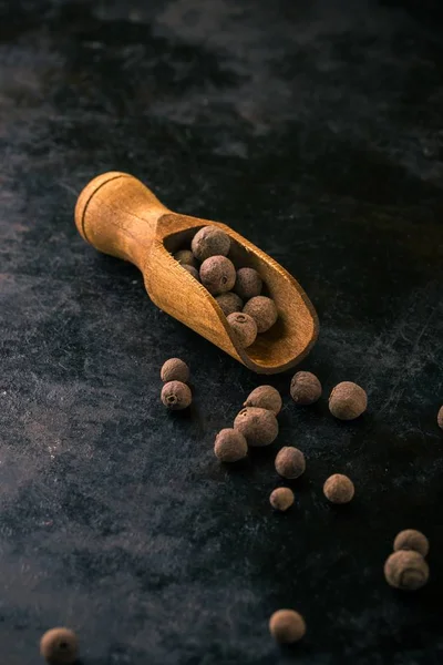 Cucchiaio di legno pieno di pimento su vassoio scuro vintage — Foto Stock