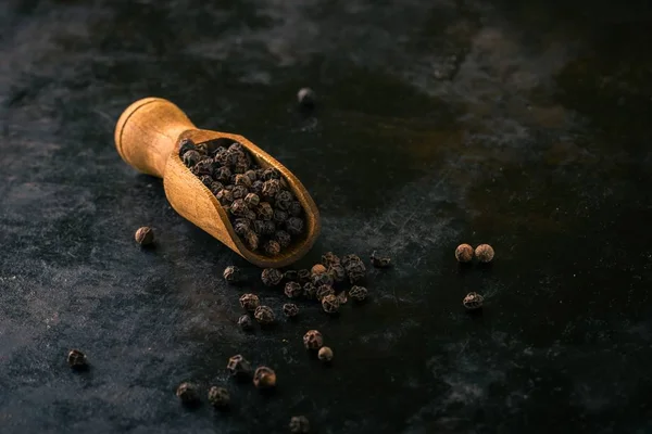 ビンテージの暗いトレイに胡椒の木のスプーン — ストック写真
