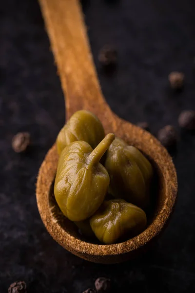 Paar stukken van kappertjes in houten lepel — Stockfoto