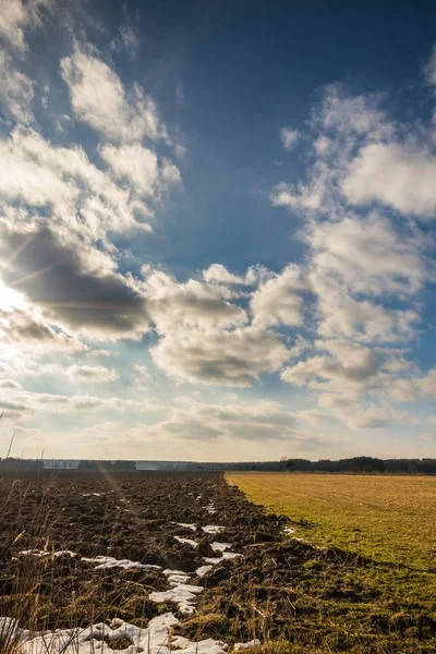 Dramatyczne zachmurzone niebo nad wczesną wiosną pole i łąka — Zdjęcie stockowe