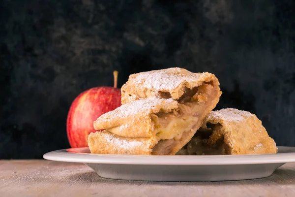 Two portions of apple strudel with sugar with red apple — Stock Photo, Image