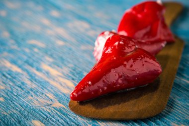 Birkaç kırmızı biber tahta kaşık peynir ile doldurulmuş