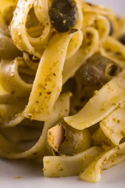 Detalhe de azeitona com amêndoa em porção de tagliatelle com pesto verde — Fotografia de Stock