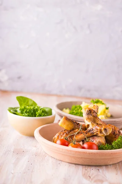 Porción de patas de pollo en plato frente a papas y ensalada — Foto de Stock