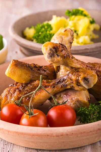 Porción de varias patas de pollo en el plato delante de papas y ensalada verde — Foto de Stock