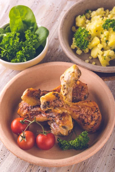 Foto vintage de patas de pollo en plato frente a papas y ensalada verde — Foto de Stock