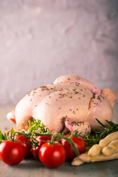 Pollo entero con especias de comino, espárragos blancos y tomates rojos —  Fotos de Stock