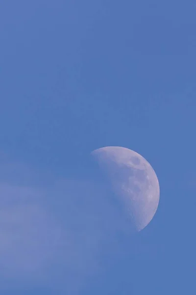 Meia lua branca com nuvem ao lado da luz do dia — Fotografia de Stock