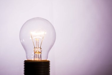 Turned on glass bulb on light background_