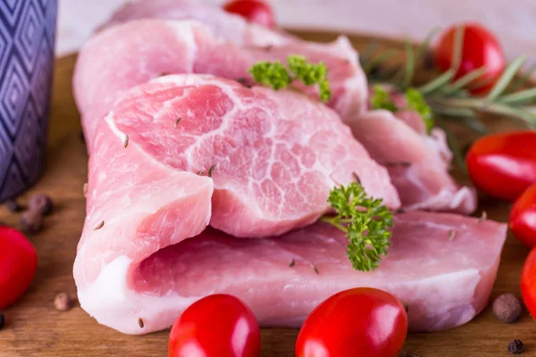 Domuz eti kırmızı domates ile ahşap tahta üzerinde birkaç uzun dilimler