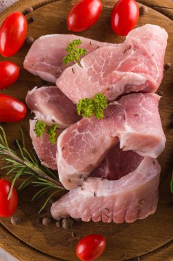 Doğrama kurulu otlar, baharat ve domates ile üzerinde birkaç domuz filets