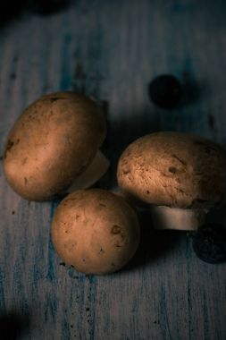 Antika ahşap tahta üzerinde ayrıntılı üç kahverengi yenilebilir mantar döktüm