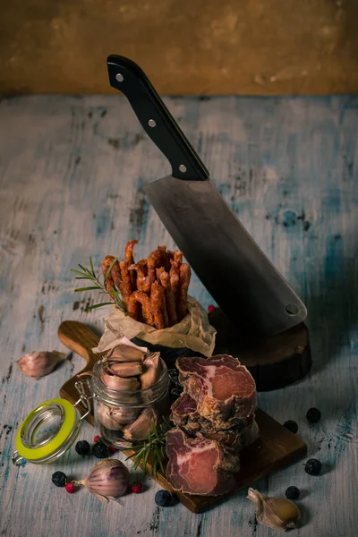 Dried italian meat from wild boar on cutting board with spiced sausages and garlic