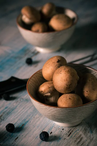 Jedlé houby v miskách na vinobraní dřevěné desce — Stock fotografie