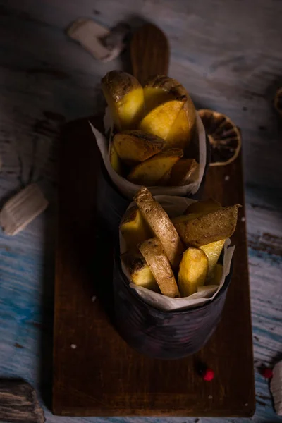 Gebakken aardappel stripps op houten bord in twee blikjes — Stockfoto