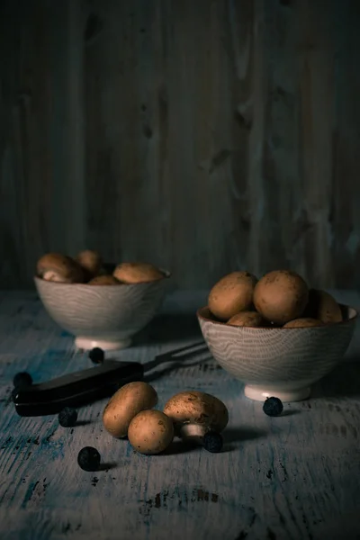 茶色の食用キノコ ヴィンテージの木製ボードと 2 つのボールでこぼれた — ストック写真