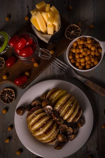 Pohled shora na pečené brambory se sýrem gouda a salám na vinobraní desce s malými rajčaty — Stock fotografie