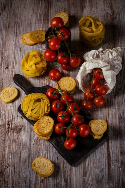 Pomodori ciliegini su diversi rametti con tagliatelle — Foto Stock