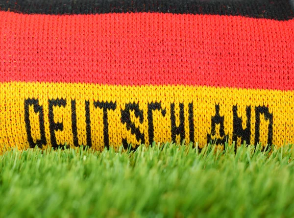 Football fan scarf in red black gold colors as national Germany flag rolled up with text in german language \