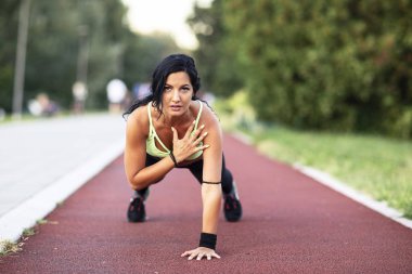 Uzun siyah saçlı kız sokakta egzersiz yapıyor.