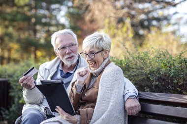 Mature man and woman shopping on line