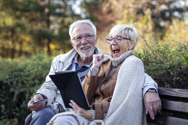 Mature man and woman shopping on line