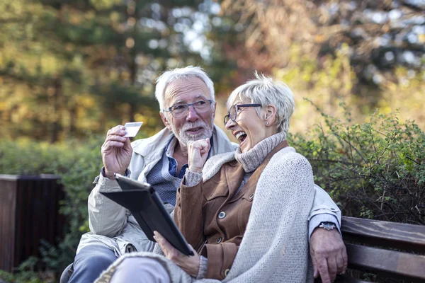 Mature man and woman shopping on line