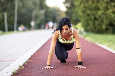 Fitness woman in sportswear exercise on the tartan track