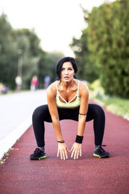 Fitness woman in sportswear exercise on the tartan track