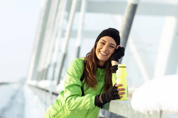 Fit woman with bottle of water on cold day