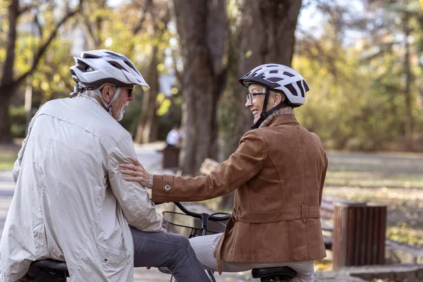 Old woman and man in park with bikes