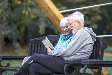 Park yerinde tabletleri olan birkaç emekli.