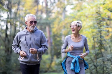 Olgun bir çift parkta koşuyor.