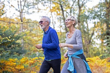 Olgun bir çift parkta koşuyor.