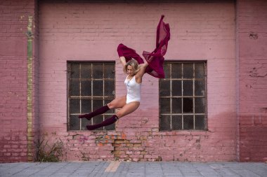 Bale dansçısı kız sokakta zıplıyor.